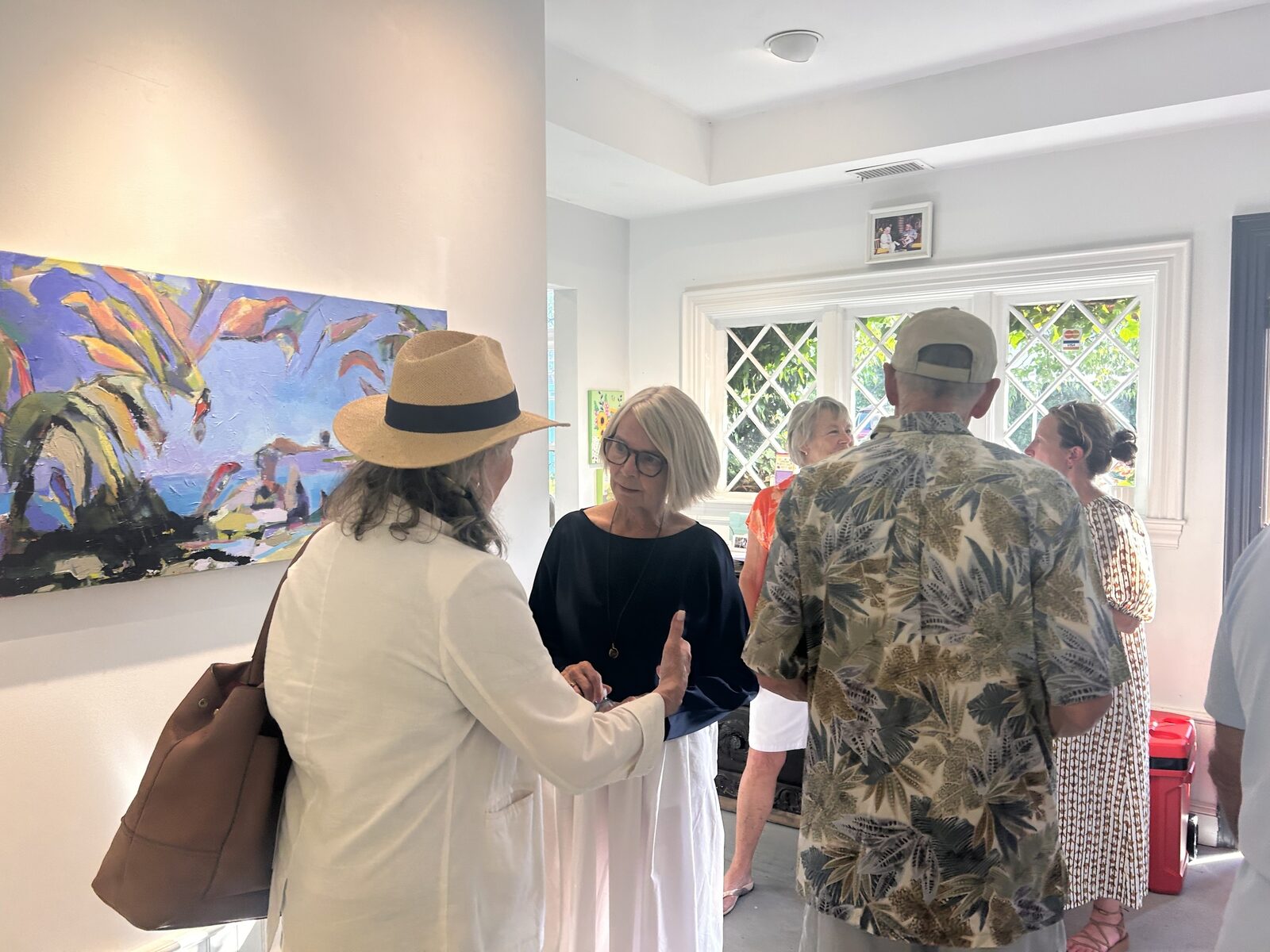 Kathy beside a painting at the opening